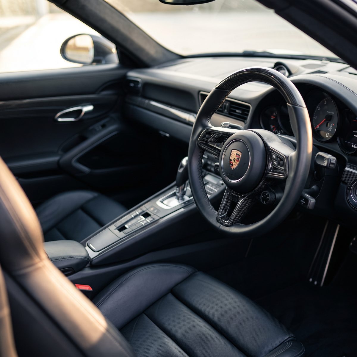 Porsche 911 Turbo S interior, driver's seat and dashboard in black leather with carbon trim
